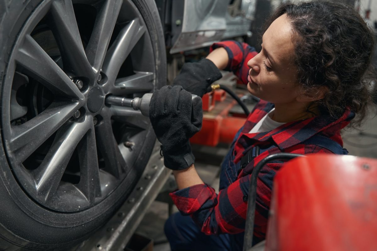 woman replacing tires of a car